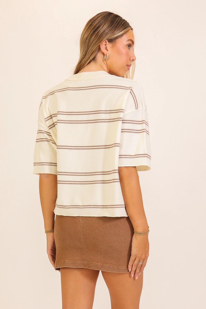 back view of woman in striped sweater and skirt 