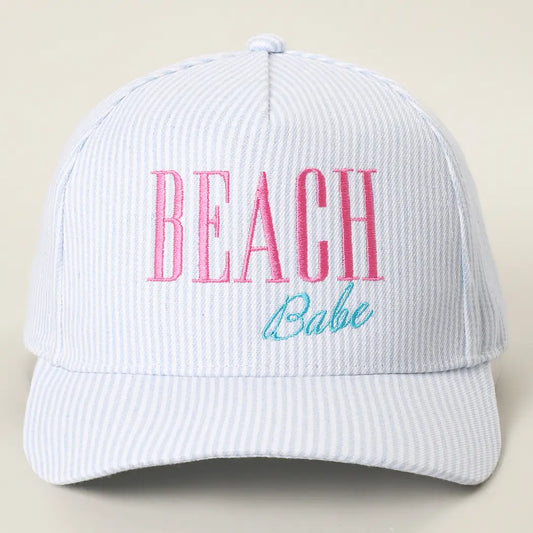 White cap with 'BEACH Babe' text in pink and blue on a beige background