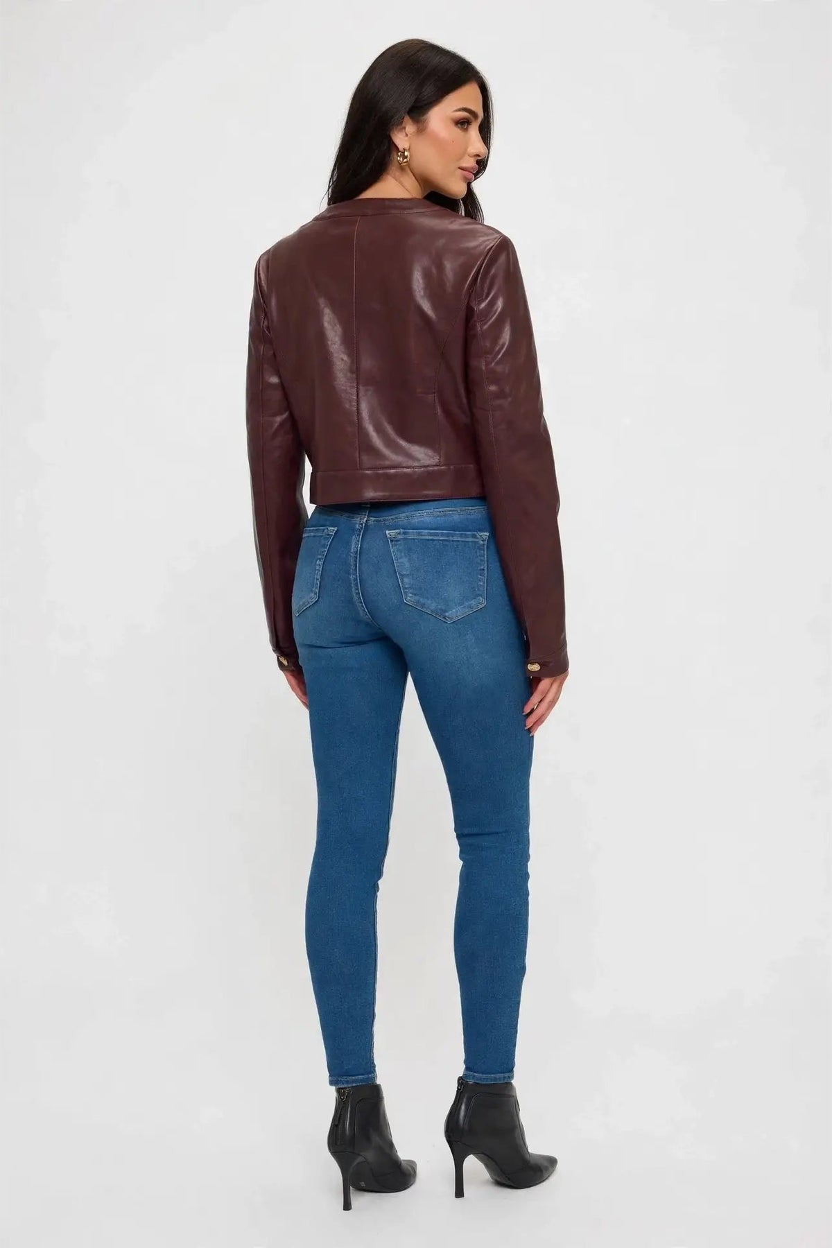 back view of woman in cropped leather jacket and jeans