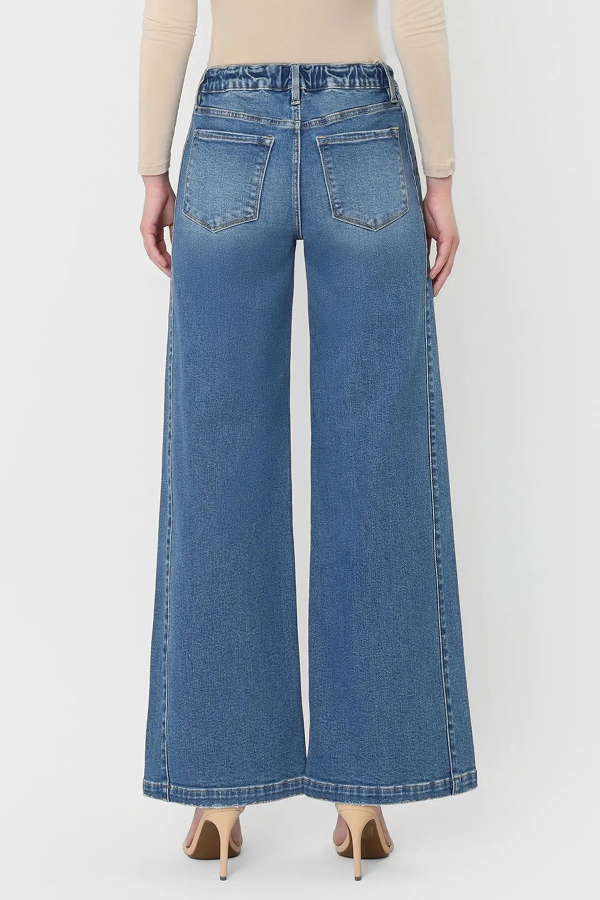 Person wearing blue wide-leg jeans on a white background