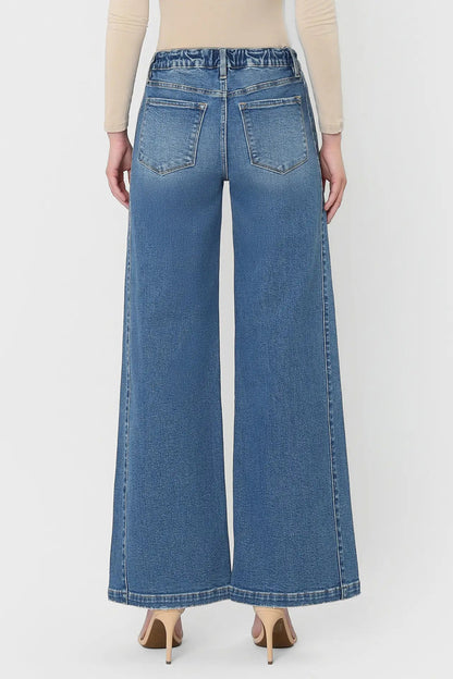 Person wearing blue wide-leg jeans on a white background