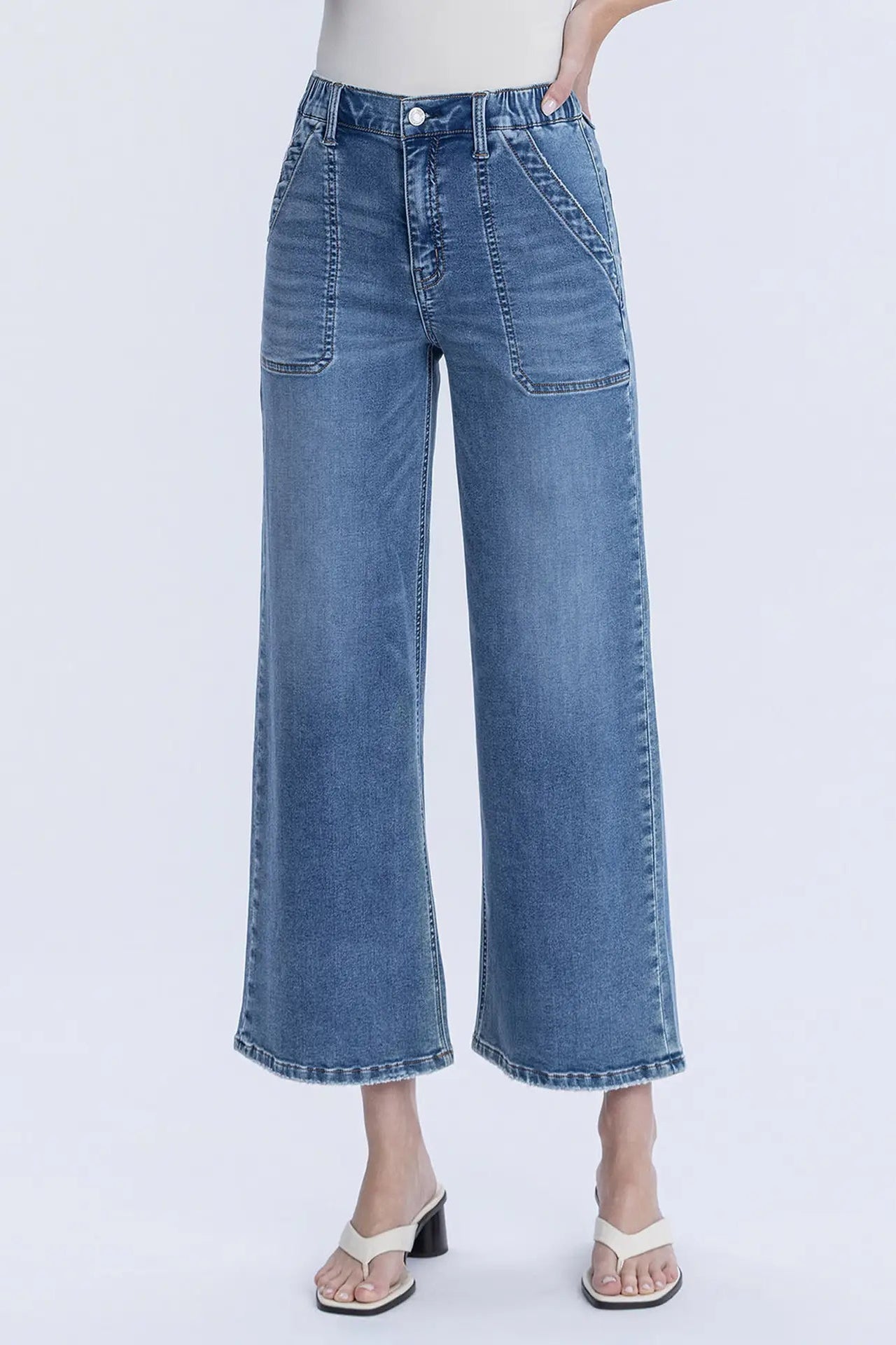 Blue jeans worn by a person on a white background