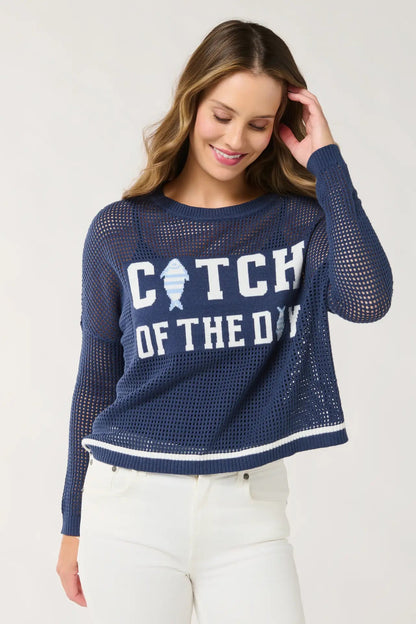 Woman wearing a navy blue mesh sweater with 'Catch of the Day' text and fish graphic on a white background