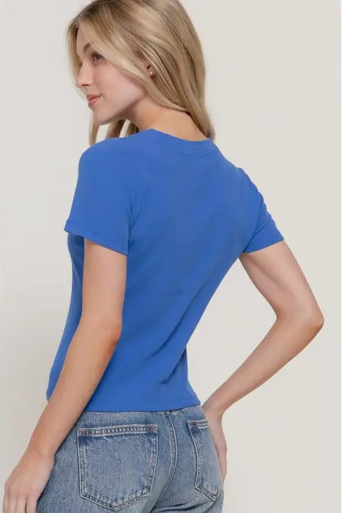 Woman wearing a blue t-shirt and jeans against a plain background