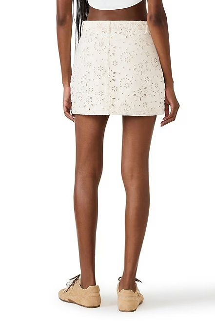 Person wearing a white floral mini skirt on a white background