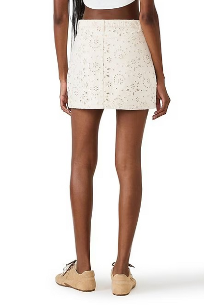 Person wearing a white floral mini skirt on a white background