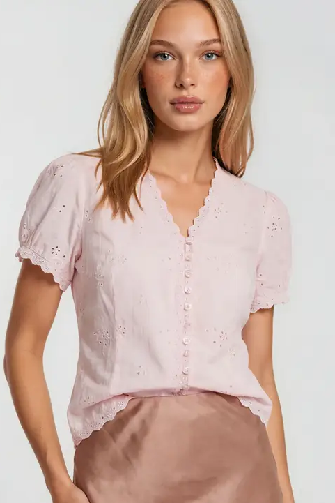 woman wearing pink eyelet blouse with tan skirt