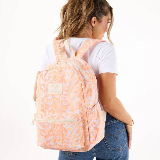 Person wearing a peach backpack with a white background
