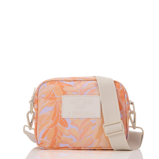 Peach-colored crossbody bag with floral pattern and 'Aloha' label on a white background