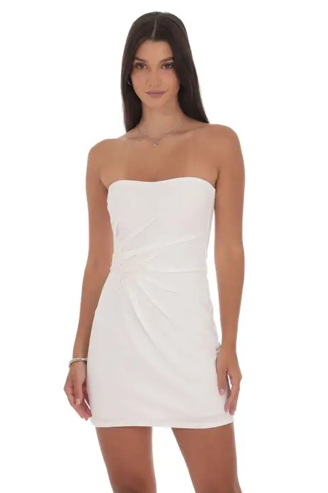 Woman wearing a white strapless dress on a white background
