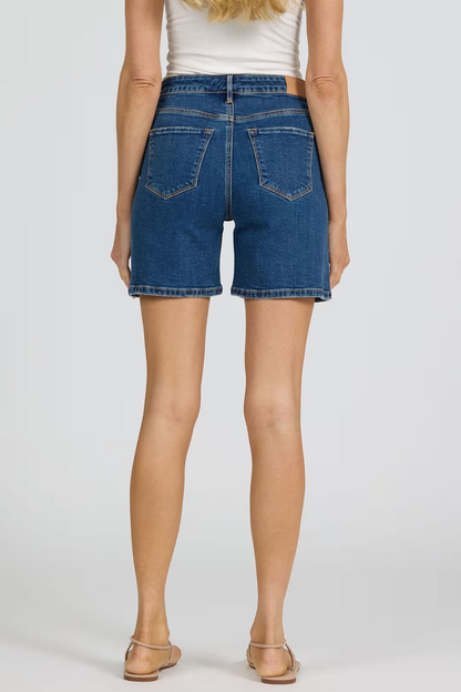 Person wearing blue denim shorts on a plain background