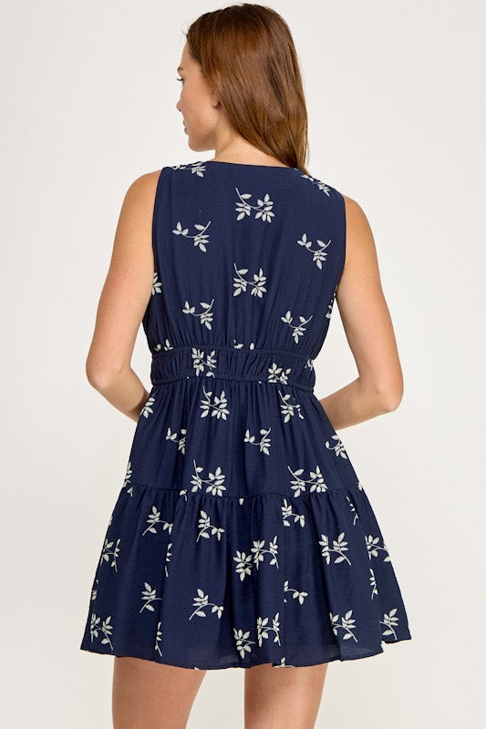 Navy blue dress with white floral pattern on a plain background