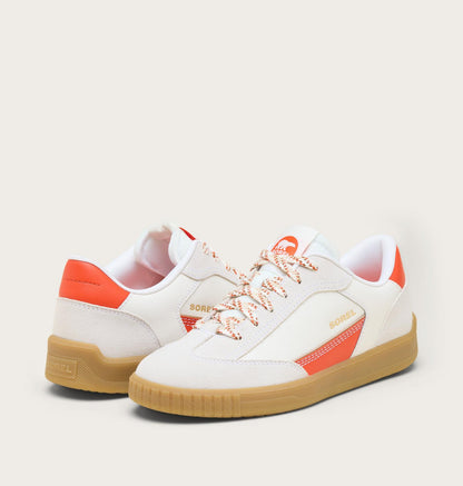 White sneakers with orange accents and brown soles on a light gray background
