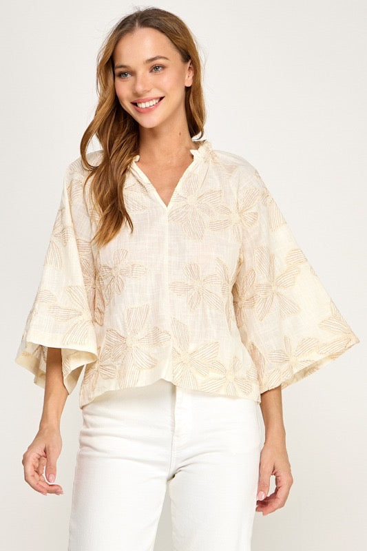 Woman wearing a light-colored kimono-style top against a white background