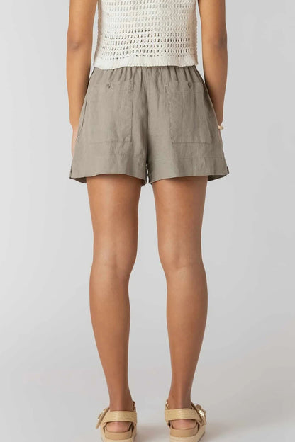 Person wearing beige shorts on a plain background