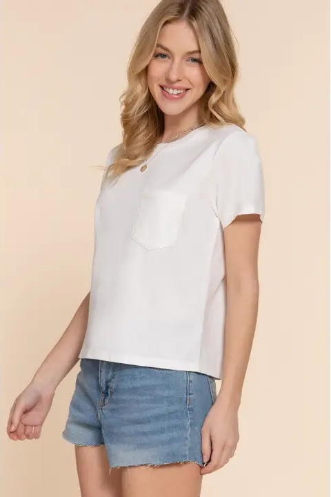 Woman wearing a white top and denim shorts on a beige background