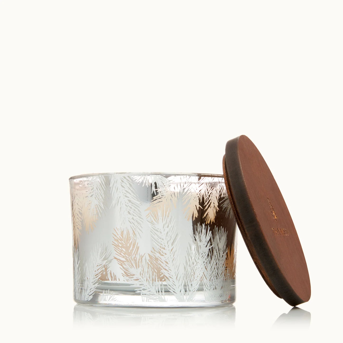 Glass candle with a textured design and a brown lid on a white background