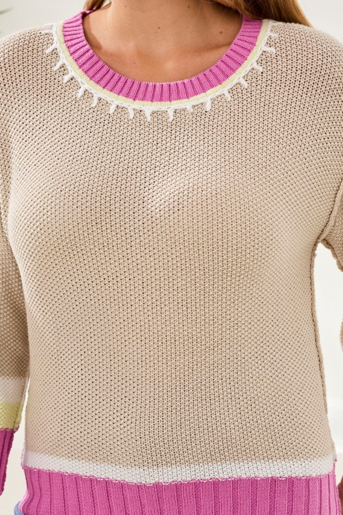 pink and beige sweater on white background