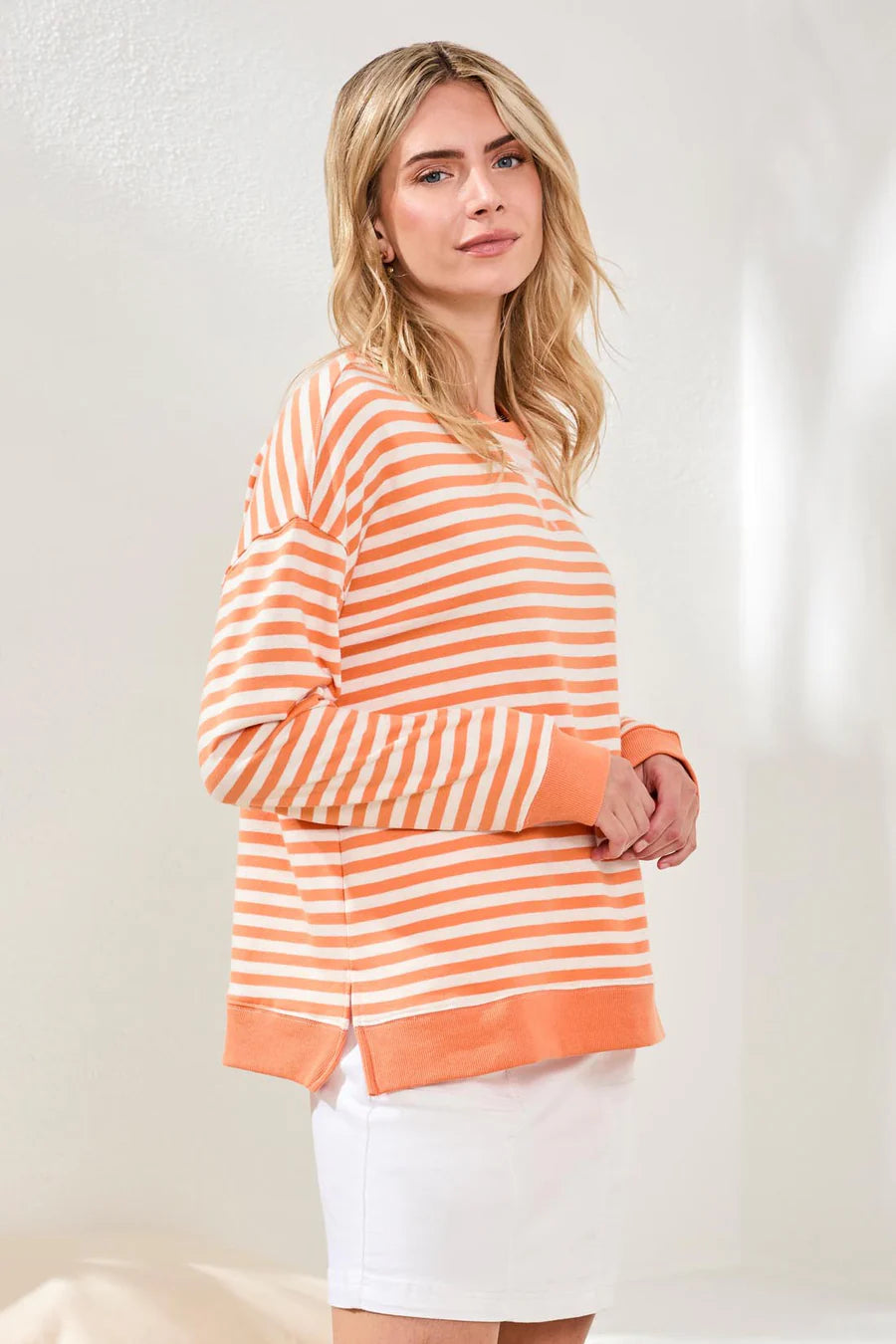 woman wearing orange striped crew neck with white skirt