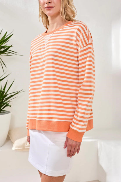 woman wearing orange striped crew neck with white skirt