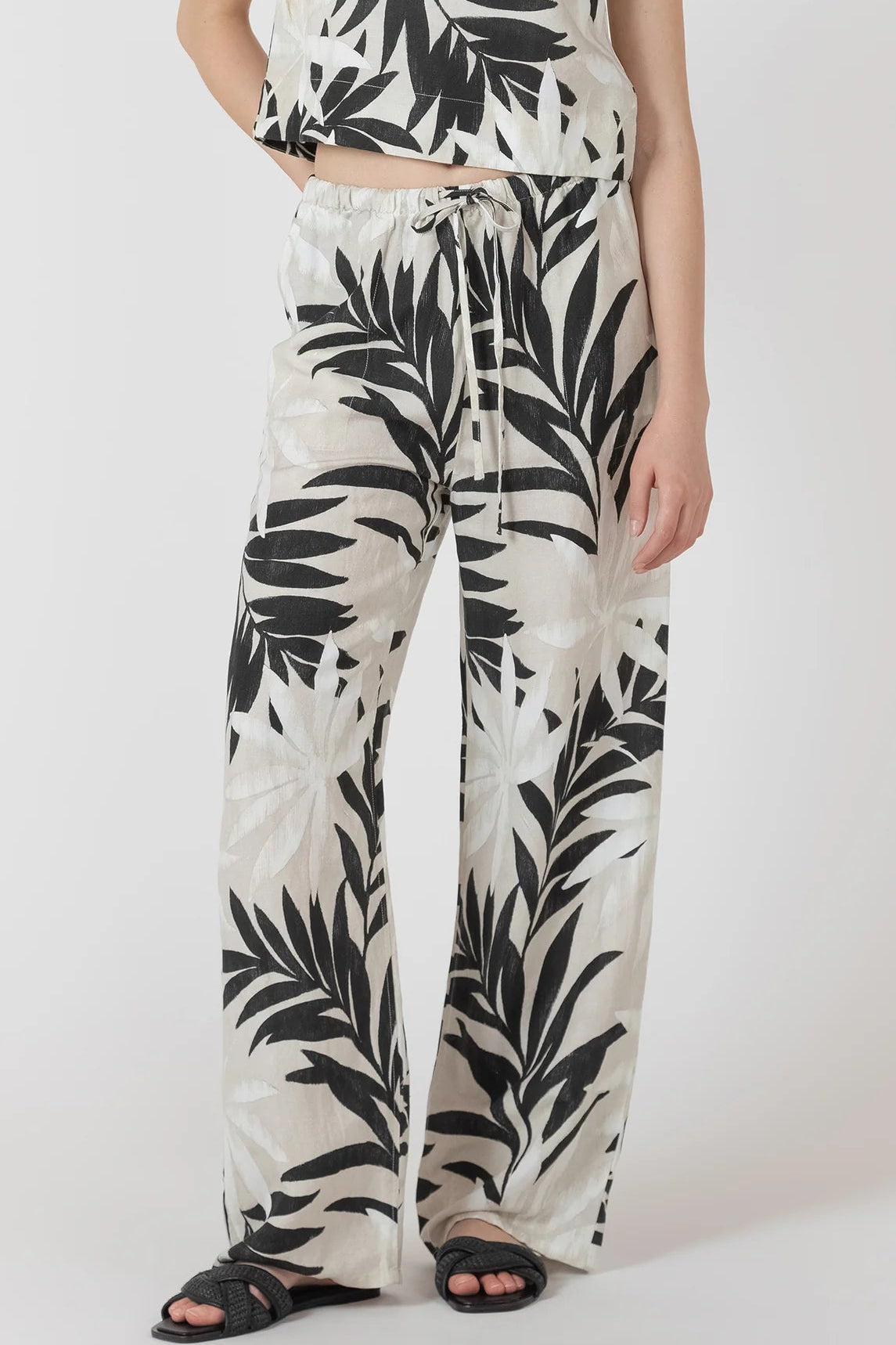 Person wearing a black and white leaf-patterned outfit on a white background