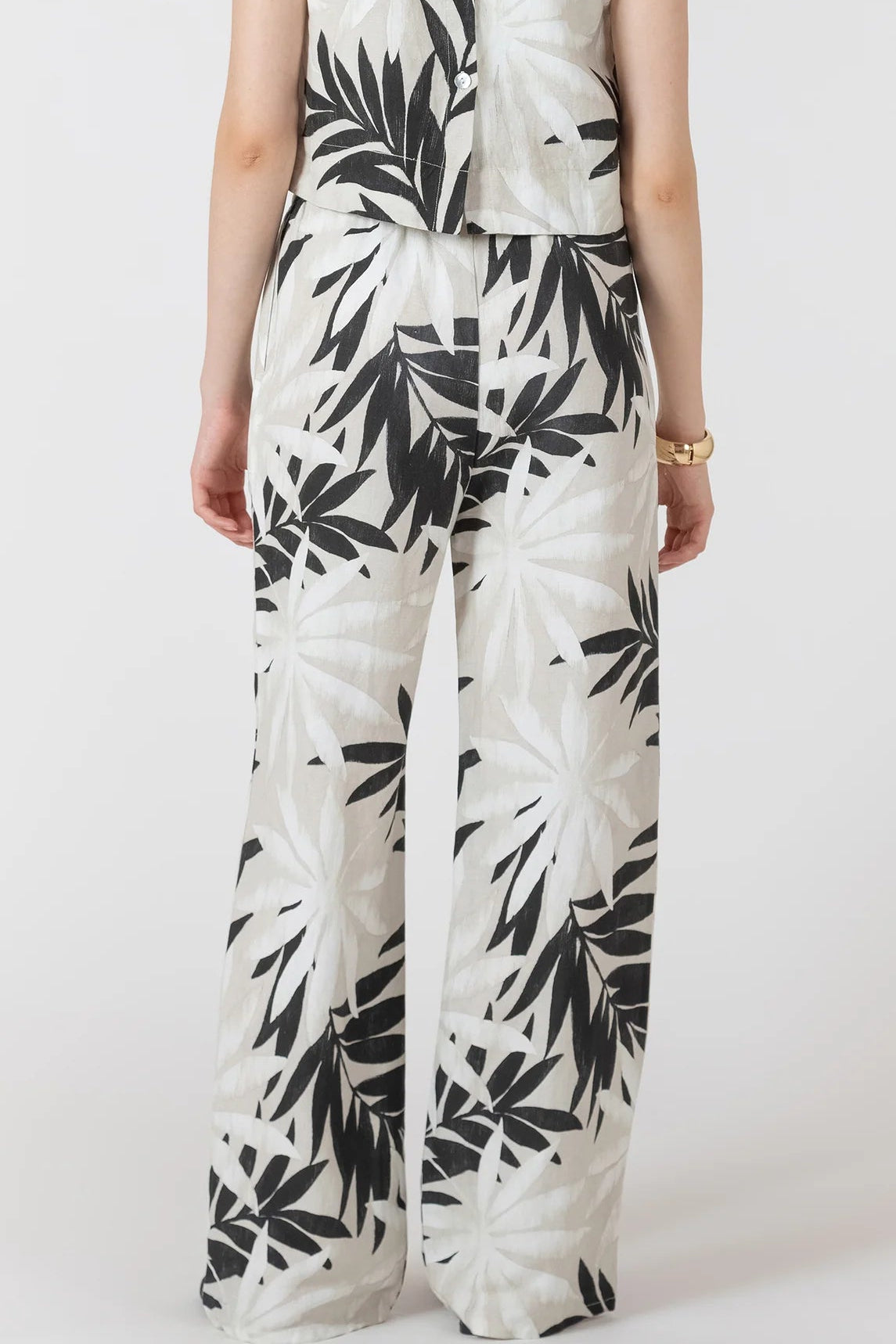 Person wearing a black and white leaf-patterned outfit on a white background