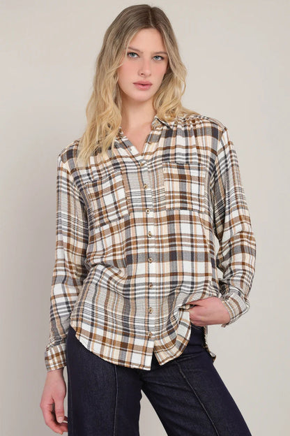 Woman wearing a plaid shirt against a plain background