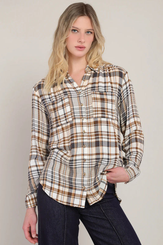 Woman wearing a plaid shirt against a plain background