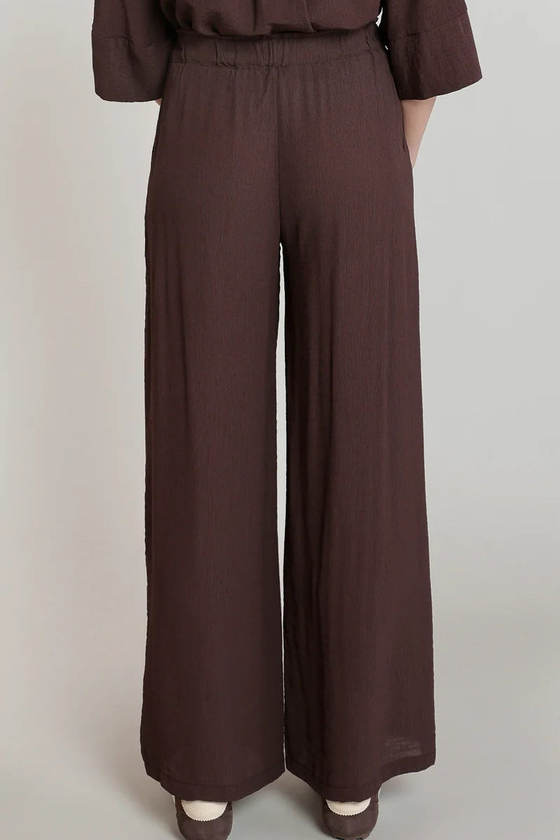 Brown wide-leg pants worn by a person on a plain background