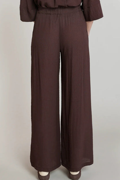 Brown wide-leg pants worn by a person on a plain background