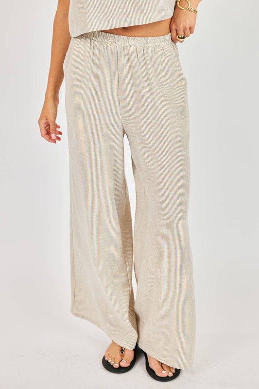 Beige wide-leg pants worn by a person on a white background