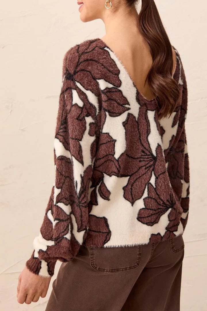 back view of woman in brown floral sweater