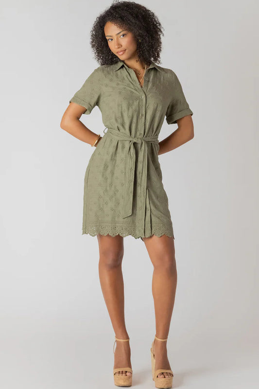 Woman wearing a green dress with a belt on a white background