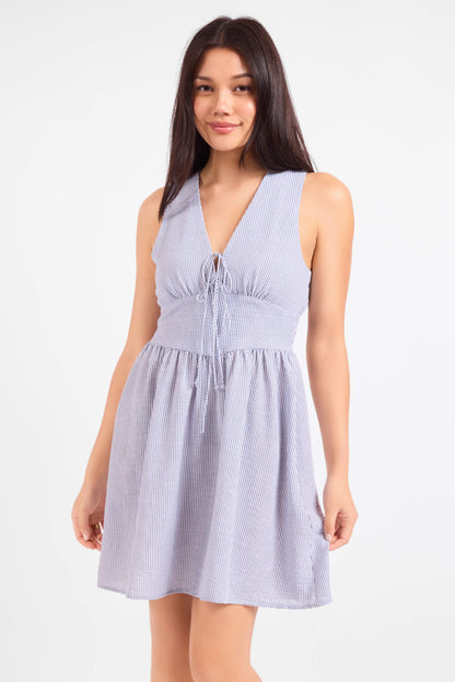 Woman wearing a light blue sleeveless dress on a white background