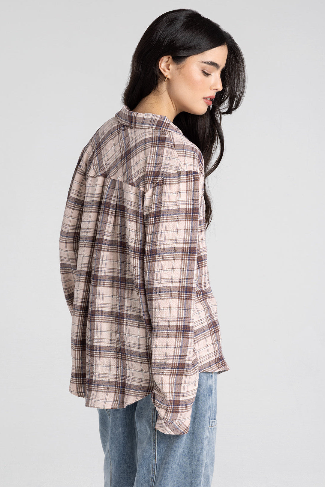 woman wearing plaid button up with jeans 