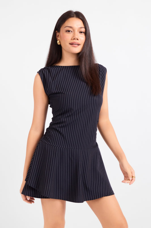 Woman wearing a black pinstripe dress against a white background