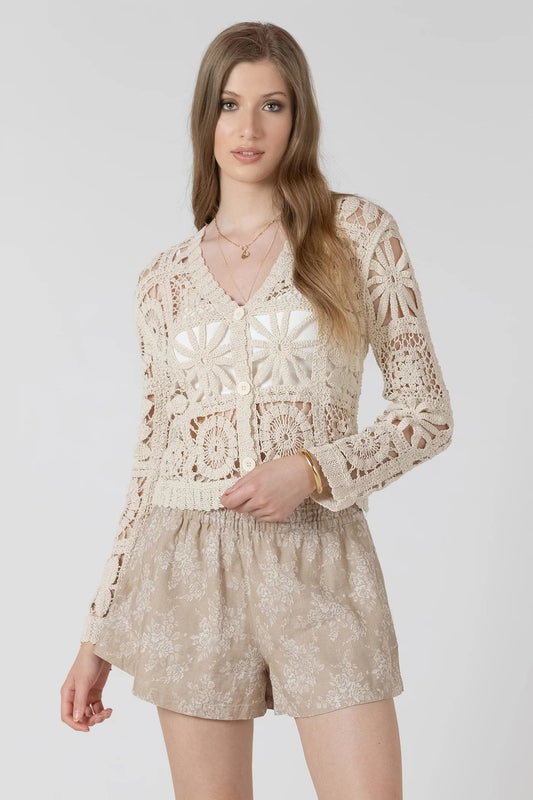 woman wearing crochet cardigan with tan shorts 