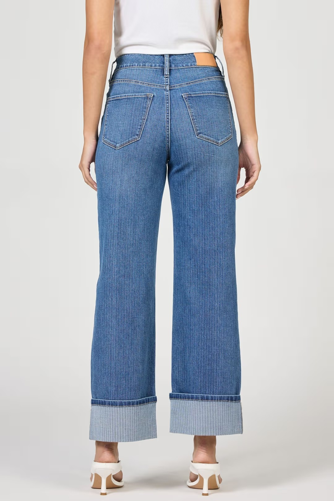Blue jeans worn by a person on a white background