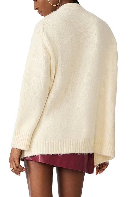 A woman shown from the back wearing a cream-colored, fuzzy knit cardigan over a burgundy skirt, against a plain white background.