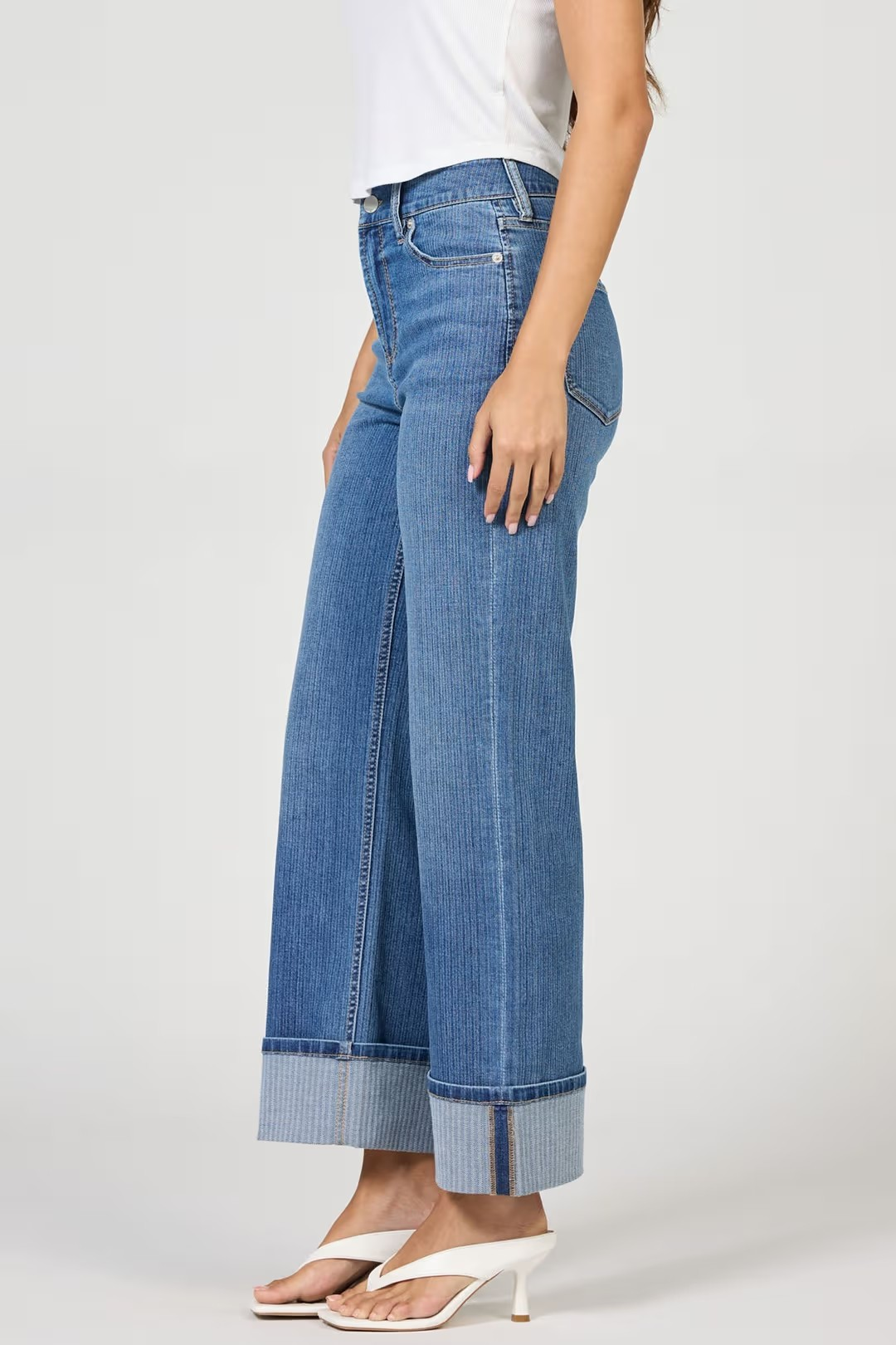 Person wearing blue wide-leg jeans on a white background