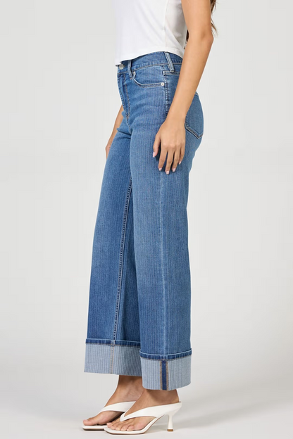 Person wearing blue wide-leg jeans on a white background